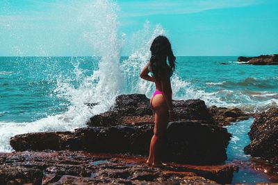 Woman in sea against sky