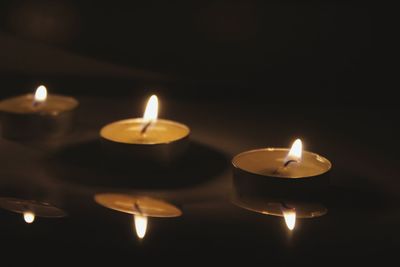 Close-up of lit candles in row