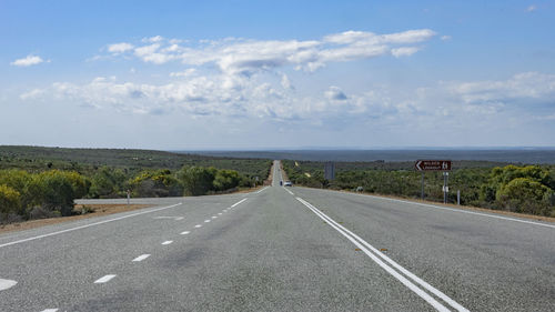 Empty road against cloudy sky