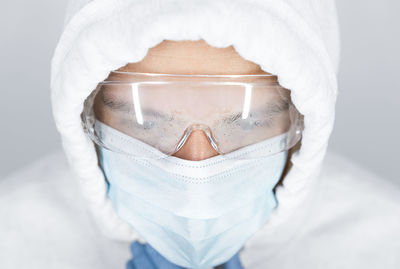 Close-up portrait of a man wearing medical mask and glasses