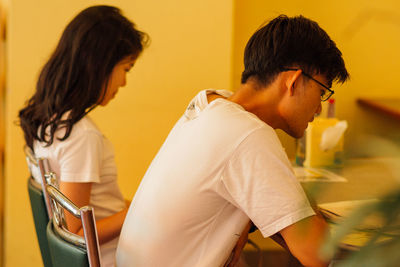 Side view of young woman drinking milk at home