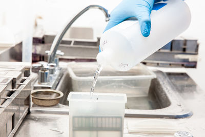 Midsection of scientist examining chemical in laboratory