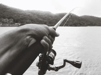 Close-up of man holding hand over river