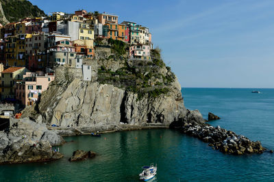 Scenic view of sea by buildings against sky