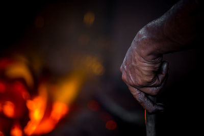 Close-up of hand holding burning against blurred background