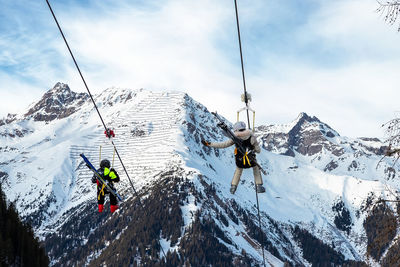 People on snowcapped mountain against sky