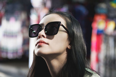 Close-up of woman wearing sunglasses at night