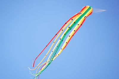 Low angle view of kite flying against clear blue sky