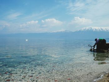 Man standing in sea against sky