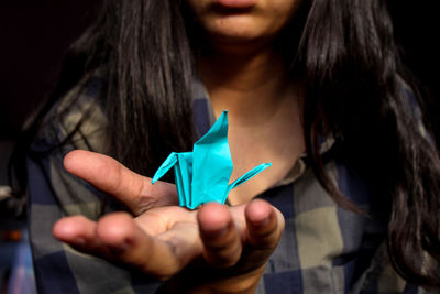 Midsection of woman holding origami