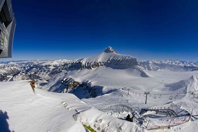 Scenic view of snowcapped mountains against clear blue sky