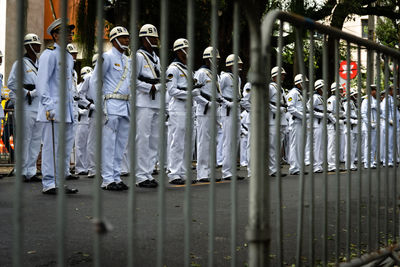 Military personnel are standing with weapons in their hands behind a guardrail on brazil's 