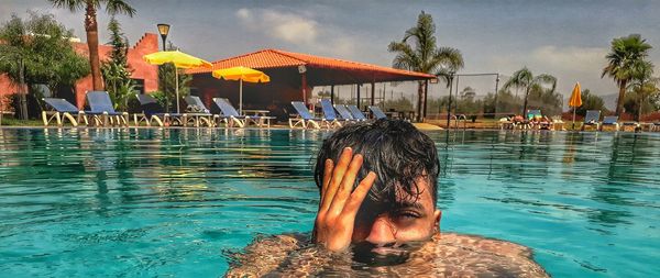 Rear view of shirtless woman in swimming pool