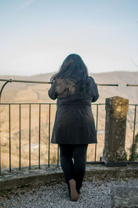 Rear view of woman standing against clear sky