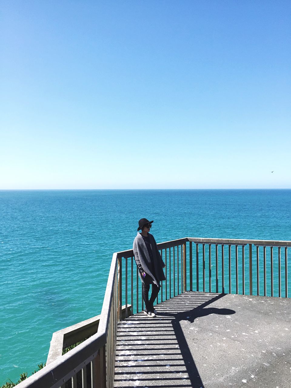 sea, horizon over water, clear sky, water, rear view, copy space, lifestyles, blue, leisure activity, railing, person, men, tranquil scene, scenics, looking at view, tranquility, standing, relaxation