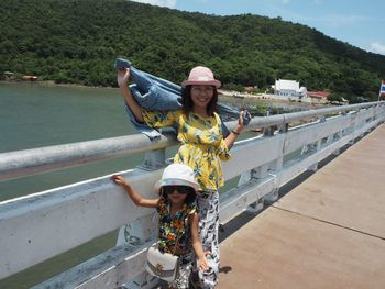 Portrait of woman standing by railing