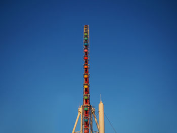 Side view of a ferris wheel and blue sky.