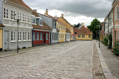 Street amidst houses against sky