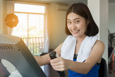 Portrait of smiling young woman holding camera