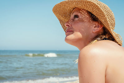 Close-up of woman in hat at beach