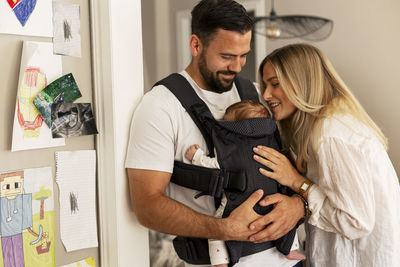 Happy parents spending leisure time with son at home