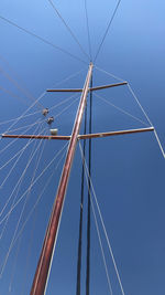 Low angle view of electricity pylon against blue sky