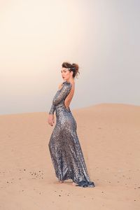 Female model posing at desert against sky