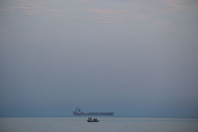 Foshing boat sailing in sea against sky