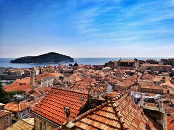 High angle view of houses by sea against sky