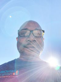 Low angle portrait of man against bright sun