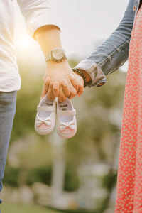 Cropped image of couple holding baby booties