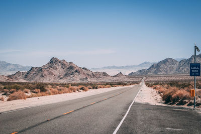 Road by mountain against clear sky