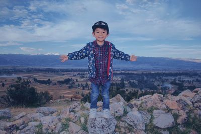 Portrait of boy standing against sky