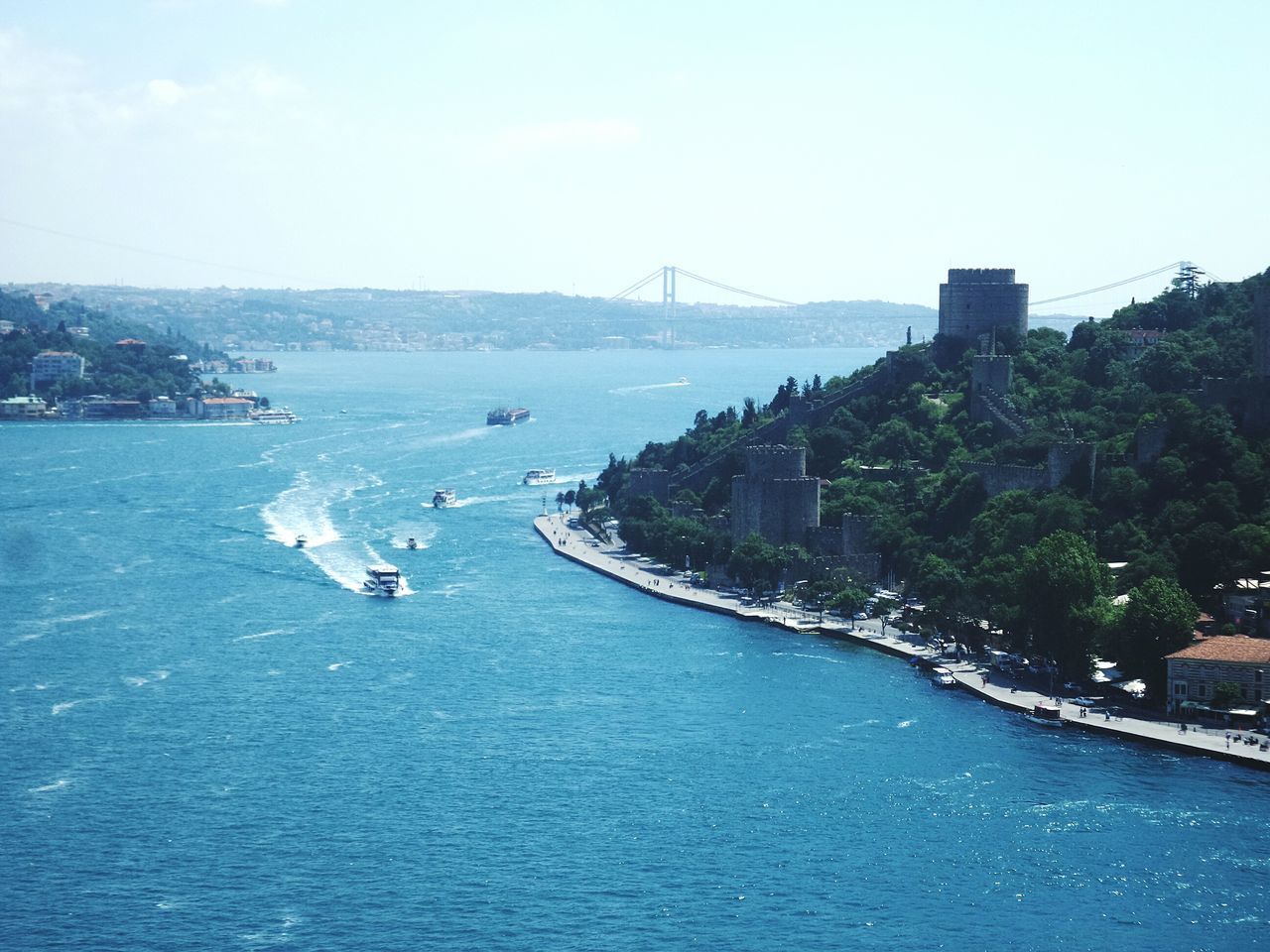 water, sea, architecture, built structure, building exterior, blue, waterfront, transportation, city, clear sky, river, sky, nautical vessel, high angle view, copy space, cityscape, tree, nature, scenics, connection