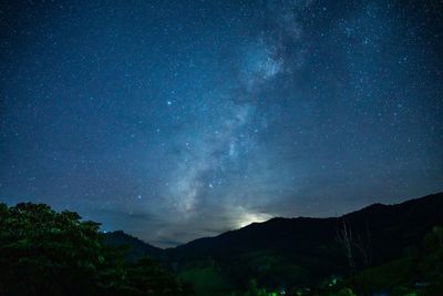 Low angle view of silhouette mountain against sky at night