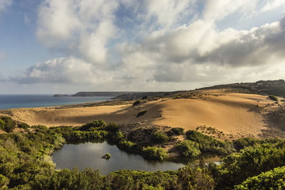 Natural landscape along the coast with dune beach, trees and lake at dawn