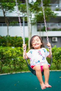 Full length of a girl holding swing in playground