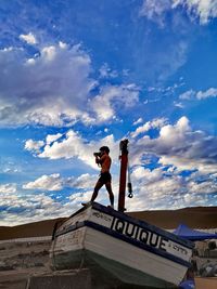 Low angle view of woman with text against sky