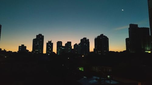 Silhouette buildings against sky at night