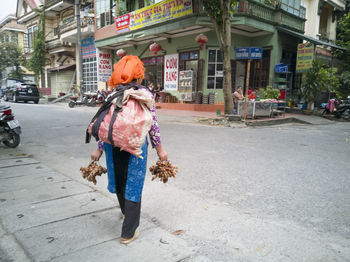 Rear view of woman walking on street in city