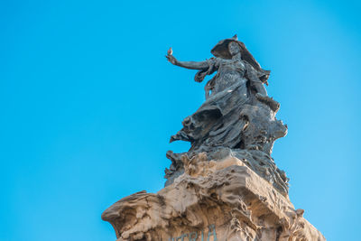 Low angle view of statue against clear blue sky