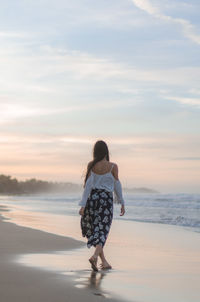 Rear view of woman standing on beach