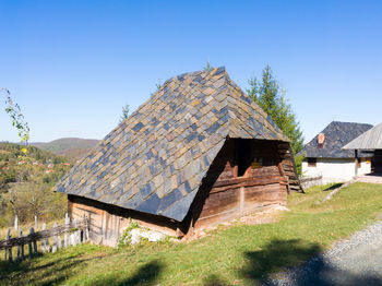Built structure on landscape against clear blue sky