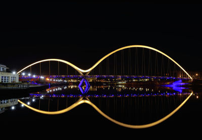 Illuminated bridge against sky at night