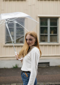 Smiling woman holding umbrella