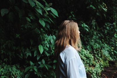 Woman standing against plants