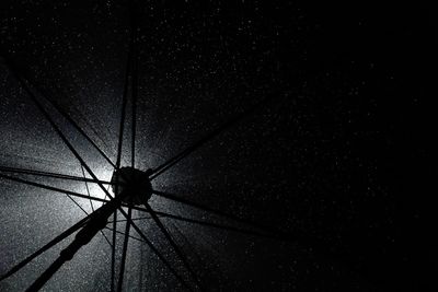Low angle view of silhouette hanging against sky at night