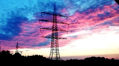 Low angle view of silhouette electricity pylon against sky during sunset