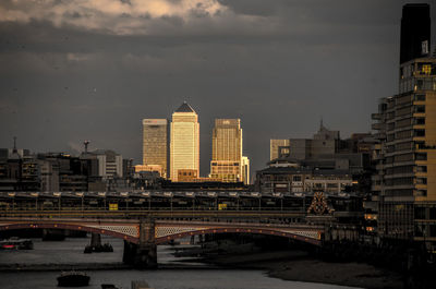 View of bridge in city against cloudy sky