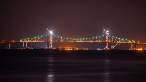 Suspension bridge over river at night